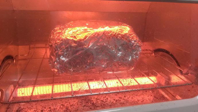 アルミホイルで包んだ牛肉をオーブンで焼く